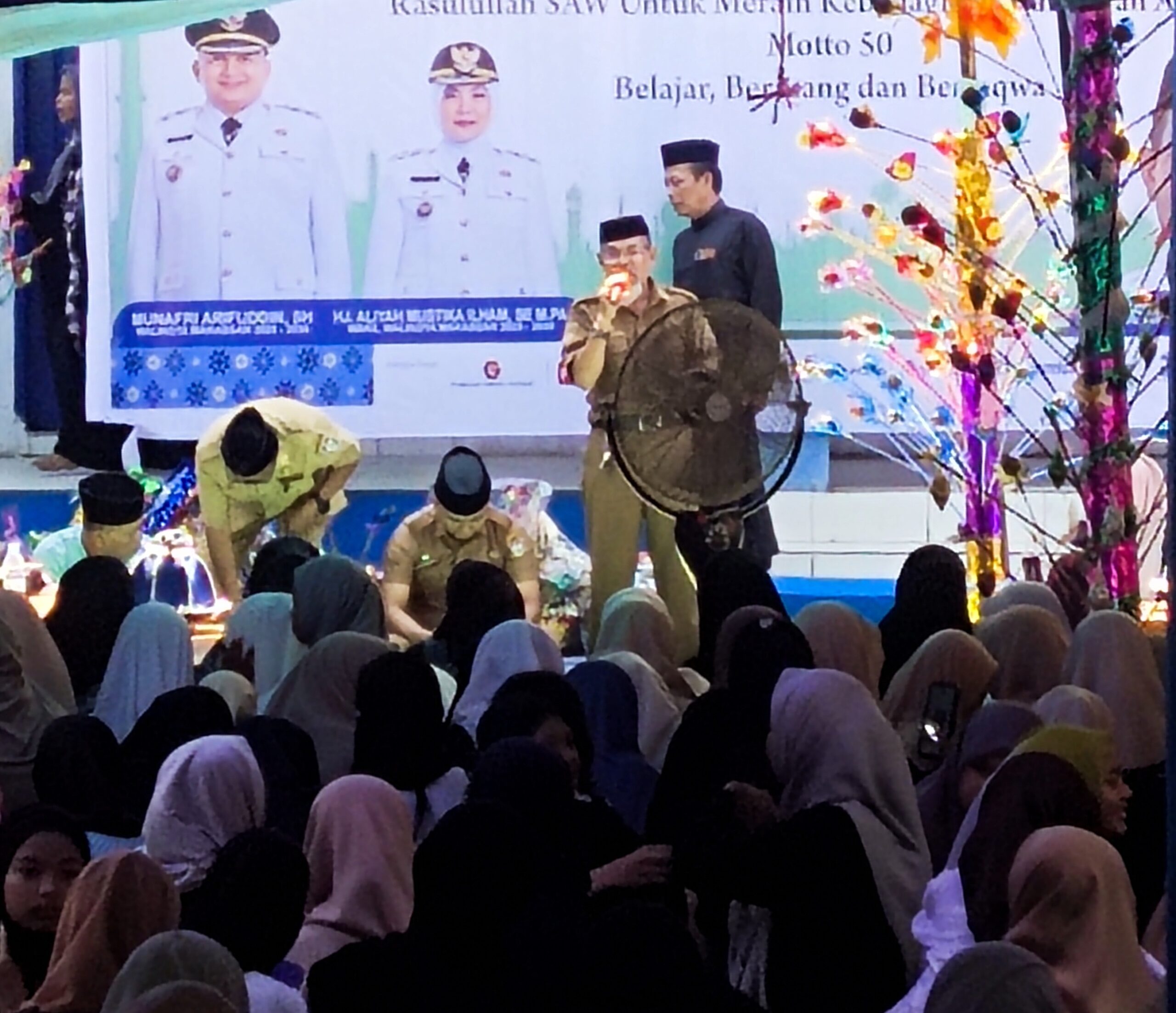 MAULID DI SMP BERTABUR TELUR DAN BAKUL. Kegiatan memperingati Maulid Muhammad SAW di SMP 50, berlangsung meriah dan penuh hikmah. Thema yang dipilih tahun ini ” dengan peringatan Maulid Muhammad meningkatkan semangat mendirikan shalat sebagai manifestasi kepada Rasulullah untuk meraih kebahagiaan dunia dan akhirat. Sedang Motto ” Belajar, berjuang dan bertaqwa. Pembawa hikmah maulid uztas H.Muchsin Ramlan S.Pdi memberikan pencerahan dan pembinaan kepada sejumlah siswa dalam mengantisipasi berbagai godaan dari perubahan zaman yang memang sangat sulit diantisipasi jika tidak dilakukan pengawasan secara rutin dan kontinyu. Uztas Mukhsin Ramlan juga menekankan untuk para orang tua senantiasa melakukan kontrol anak didik, khususnya diluar jam sekolah. Sementara kepsek SMP 50, And.Azis Hasan S.pd.MM, melaporkan dimana kegiatan maulid merupakan kegiatan yang rutin dilaksanakan dengan harapan suri tauladan yang terkandung dalam sikap Nabi Muhammad SAW, dapat di teladani oleh para siswa-siswi sehingga sikap dan etika tertanam di benak anak didik. Diakhir kegiatan tampil ketua komite sekolah Ir Rahmawajid Dgn. Bani MM, dengan menyampaikan strategi kerjasama sehingga secara marathon SMP 50 terus mengalami perbaikan sarana prasarana dan penataaan wilayah sekolah. Diakhir sambutannya ketua komite juga menjelaskan bagaimana dirinya bersama personil komite melakukan jemput siswa dilapangan bagi masyarakat yang berkategori miskin ” kami tidak ingin ada masyarakat dalam wilayah sekitar sekolah tidak sekolah” katanya yang disambut tepuk tangan hadirin dan orang tua siswa